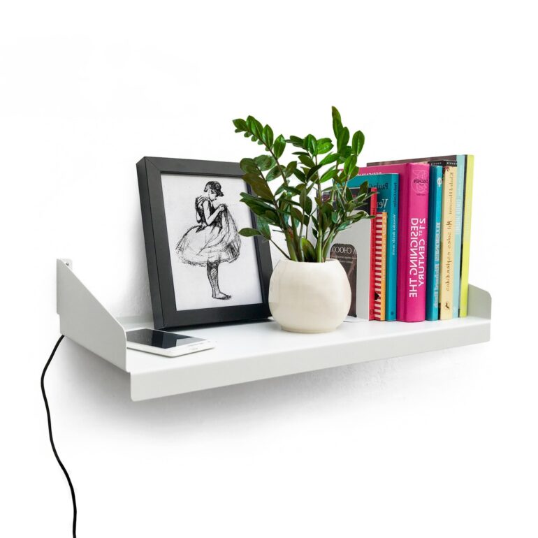 Estante FIT Muett blanco con objetos decorativos, cuadro, con libros y celular con pasacables cargador y maceta con planta pequeña en ambiente moderno