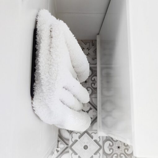 Gancho DOJO Mediano Muett instalado en pared de baño, diseño funcional moderno minimalista con toalla colgada