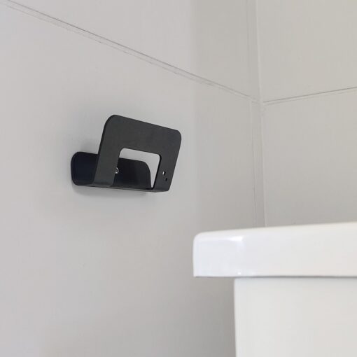 Gancho DOJO Mediano negro Muett instalado en pared de baño, diseño funcional moderno minimalista