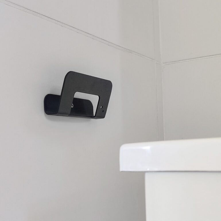 Gancho DOJO Mediano negro Muett instalado en pared de baño, diseño funcional moderno minimalista