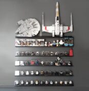 Estante LINE de 120cm en acero plegado, color negro, diseño moderno y minimalista, con colección de juguetes coleccionables, star wars, lego, figuras de colección, sobre pared color negro Muett
