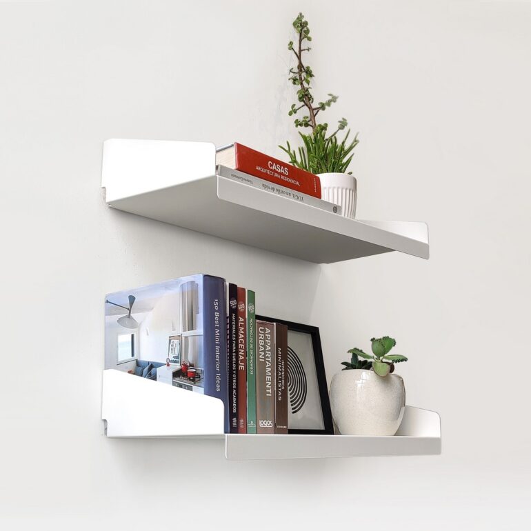 Set de Estantes FIT Muett blanco con libros, revistas y macetas con plantas objetos decorativos, cuadro fondo claro