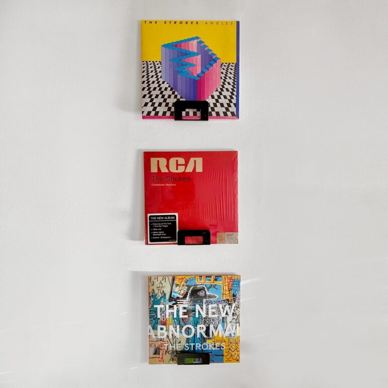 Gancho DOJO Mediano negro con vinilos Muett instalado en pared, diseño funcional moderno minimalista