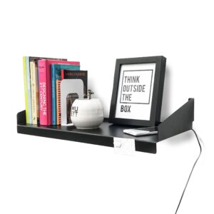 Estante FIT Muett negro con objetos decorativos, cuadro, con libros y celular con pasacables cargador en ambiente moderno