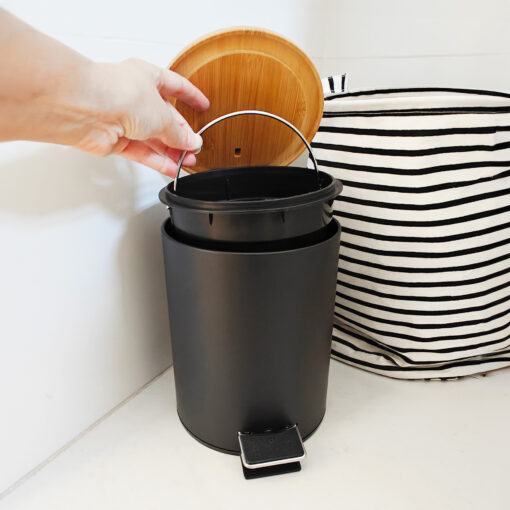 Tacho de basura NORD negro, mostrando el contenedor plástico extraíble con un cesto laundry de fondo, diseño escandinavo.
